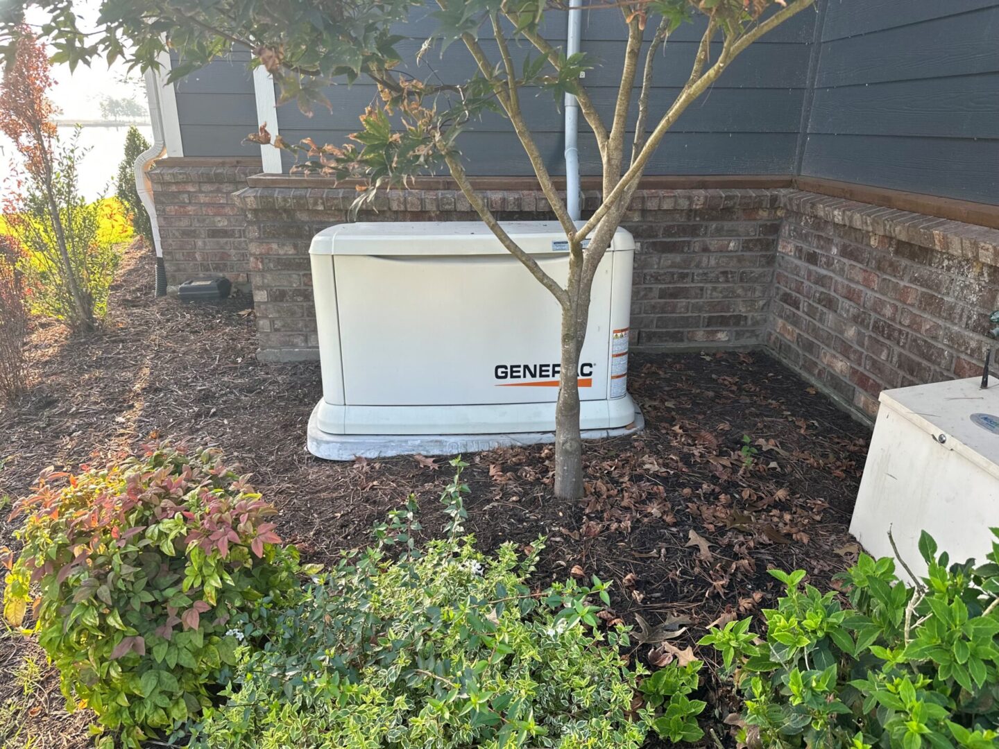 A small generator sitting in the middle of a yard.