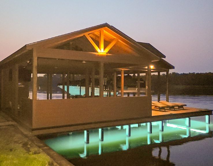 A dock with lights on the water at night.