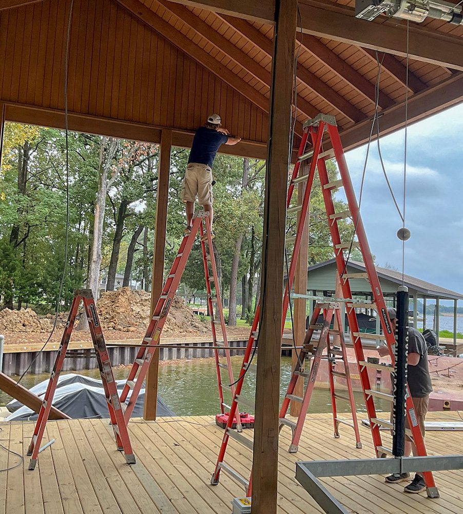 A man standing on top of a ladder.